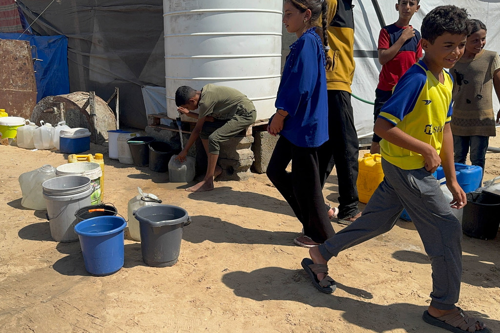 Children collect water in southern Gaza.